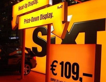 Orange Beleuchtete Werbung für die Autovermietung SIXT
