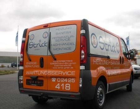 Werbung für ein Sanitärunternehmen auf einem orangefarbenen Lieferwagen