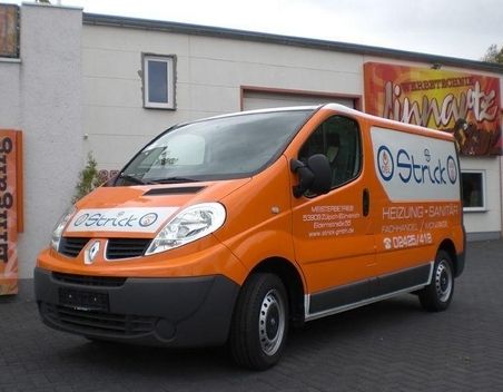Werbung für ein Sanitärunternehmen auf einem orangefarbenen Lieferwagen