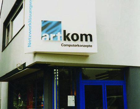 Beleuchtetes Firmenschild über einem Hauseingang