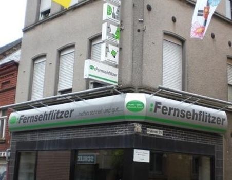 Eckgebäude mit einem Geschäft namens und grüner Beschilderung darüber