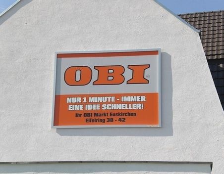 Plakat für einen OBI Baumarkt an einer Hausfassade