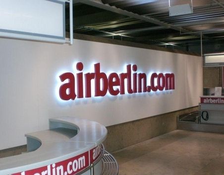 Beleuchtetes Airberlin“-Schild über einem Flughafen-Check-in-Schalter